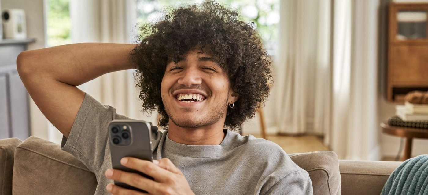 Persona tranquila revisando su celular en casa