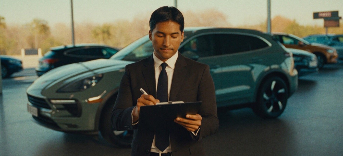 Asesor firmando el contrato de un carro en un concesionario